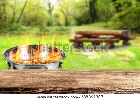 dark brown desk top burning grill and big wooden table in garden