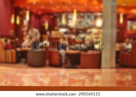 blurred red interior of cafe and red glasses desk space