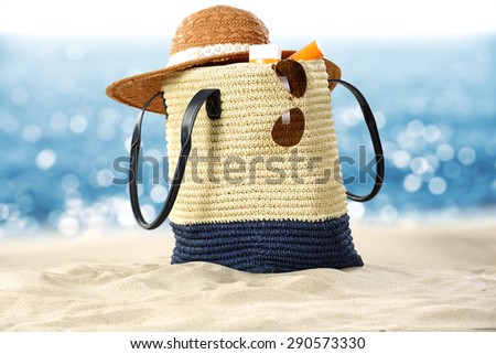 summer bag on sand and glasses with hat and sea