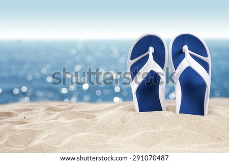 blue shoes on sand and blurred background of sea