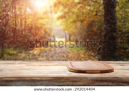desk of brown color on wooden top and autumn forest of sun