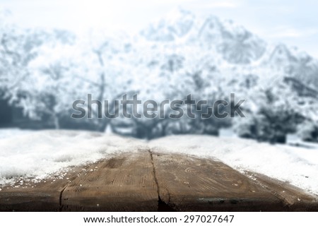 blue landscape of winter trees and mountains and dark brown desk top