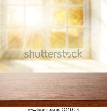 blurred background of window with sun light and dark brown desk space