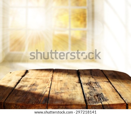 blurred background of window with sun light and empty desk space and shadow on top