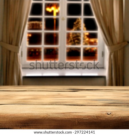 window of winter with xmas tree on street in city and desk of wood space