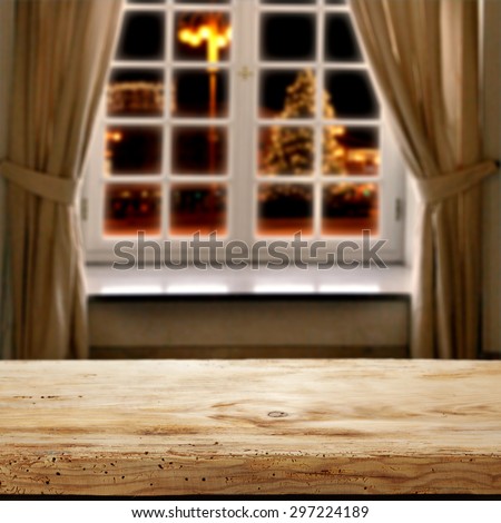 window of winter with xmas tree on street in city and desk of wood