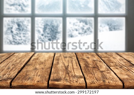 blurred background of winter window landscape and desk space of wood and free place