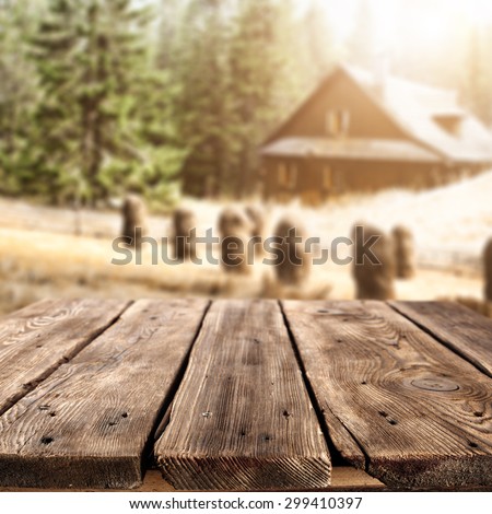 dark brown wooden table of empty space and background of farm with old home