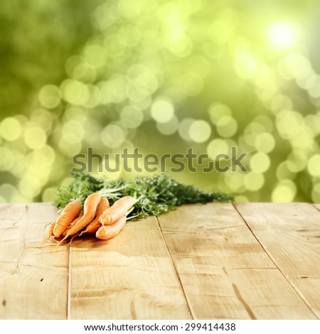orange and green colors of carrots and green blurred background of garden with sun