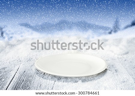 white empty plate and wooden board of frost and snow