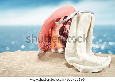 summer bag with white towel and sand on beach