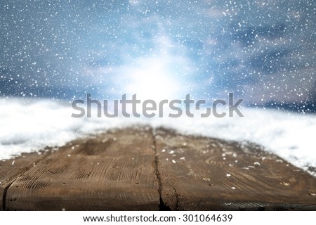 wooden desk space and white snow on top and winter sunset time