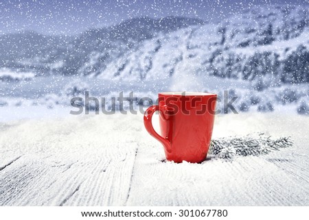 winter table with single red mug and landscape of mountains