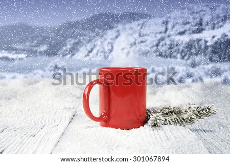 wooden table of red mug and snow