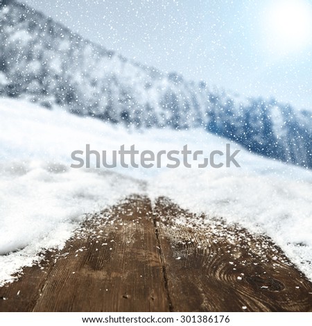 wooden table of snow forest of snow snowflakes on board and sunlight