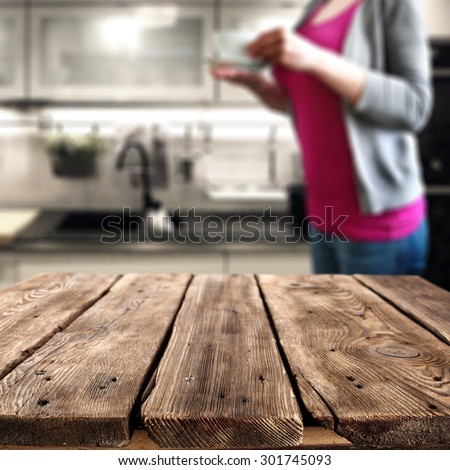 dirty wooden table in kitchen interior of white color and woman