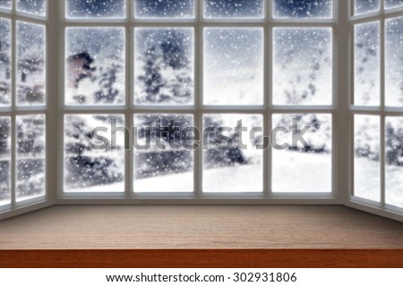 blurred background of window with winter landscape and dark brown furniture top