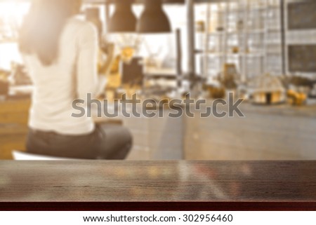 blurred background of bar with woman on chair and dark brown desk space for your decoration