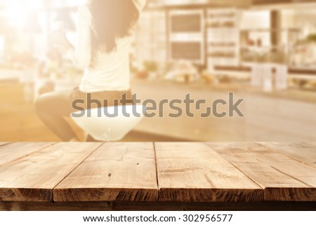 blurred background of bar with woman on chair and sunny light in room and desk