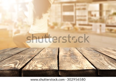 blurred background of bar with woman on chair and deck of wood