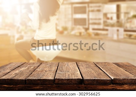 blurred background of bar with woman on chair and dark brown desk space