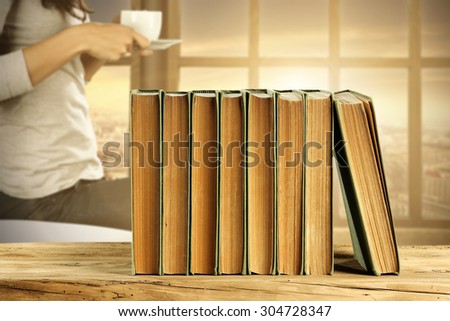 few brown books on brown desk of wood window and sun light of sunset time