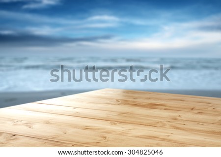 dark blue blurred background of sea and sky and yellow desk top of wood and space for you