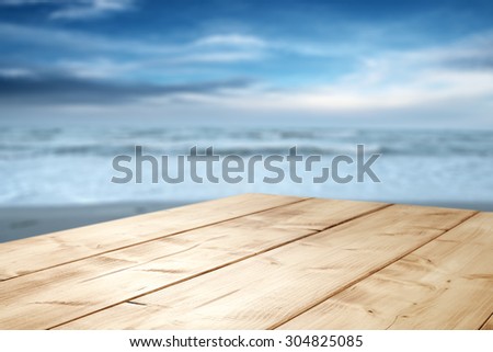 dark blue blurred background of sea and sky and empty desk space of wood