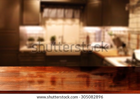 blurred background of red kitchen interior and red desk top with shadow