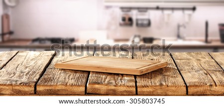 free space for you on wooden kitchen desk and blurred background of kitchen