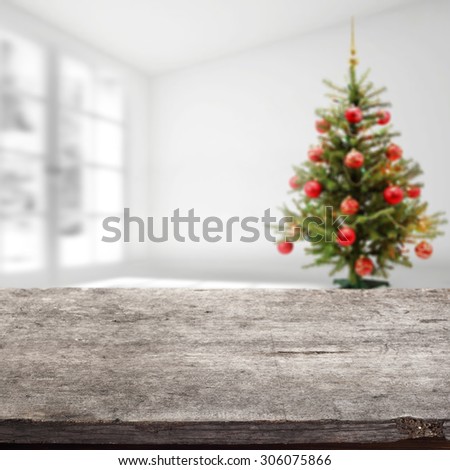 gray wooden desk space and xmas tree in home and white wall