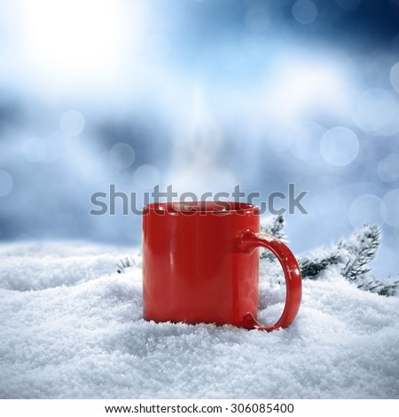 blurred background of winter frost and closeup of red mug