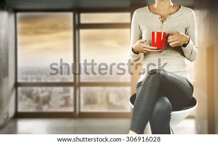 woman with red mug on chair