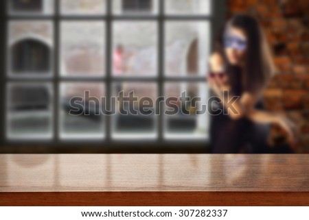 dark brown desk top and woman in mask and window place