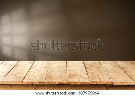 blurred brown wall with shadow space of window and yellow wooden desk top