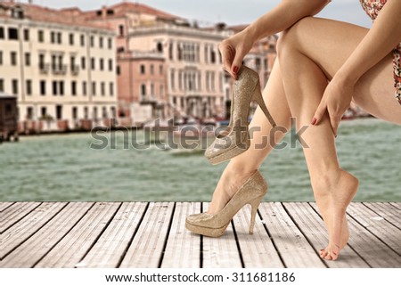wooden old pier in venice and woman legs