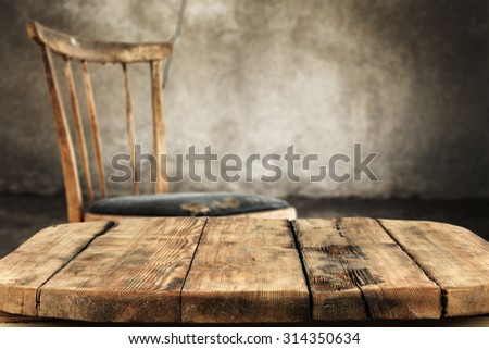 gray old worn wall in interior with retro chair and shabby wooden desk space