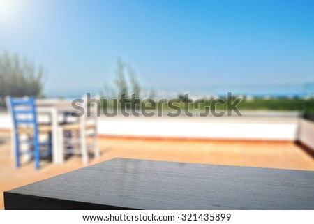 blurred background of white and blue chairs with table on terrace and black board