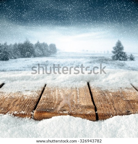 blurred background of winter and gray trees and forest and wooden worn table