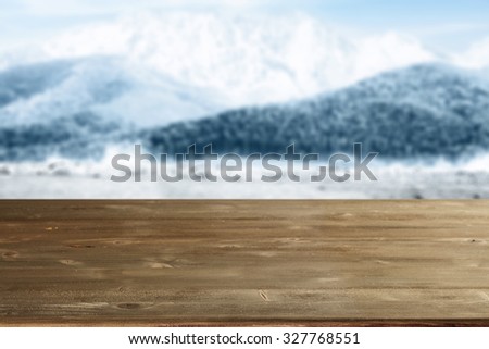 blue blurred texture of winter mountains and gray desk of wood