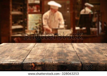 dark interior of restaurant with kitchen chef and deck top