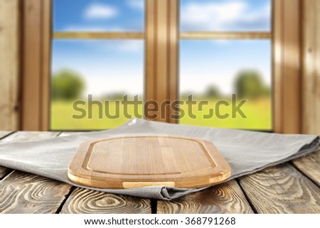 blurred background of brown wooden window space and yellow wooden desk space and napkin of gray color