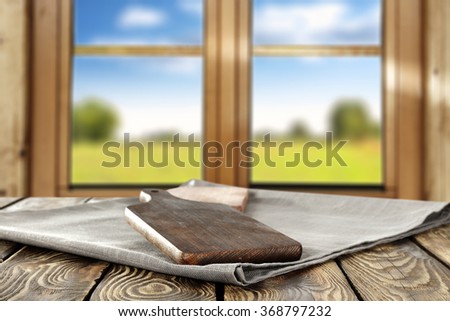 spring wooden window space in blurred background and gray napkin and kitchen board
