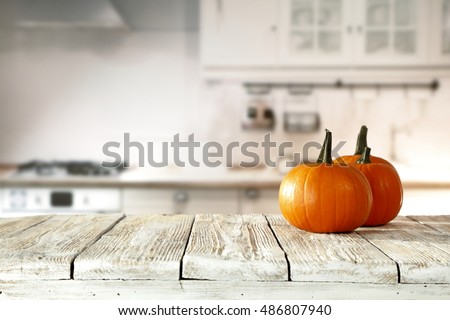 Solar autumn pumpkin in the kitchen on a white table