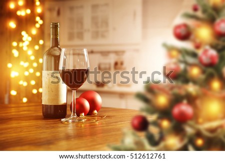 Wooden table in kitchen place and christmas wine on top with blurred xmas tree