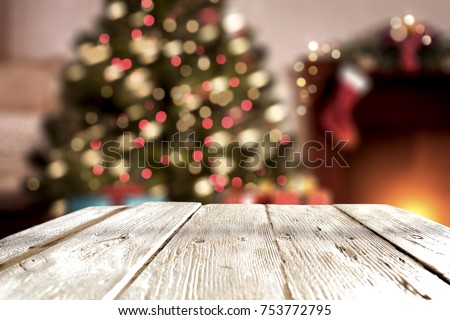 A table with space for your advertisement. Christmas tree with lights. House Interior.