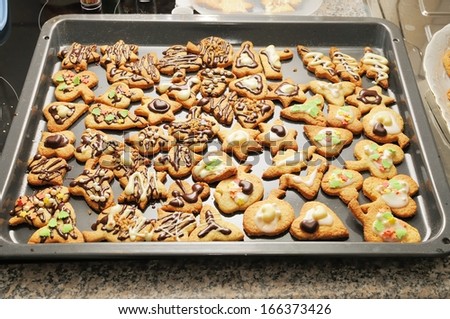 baking tray full of homemade, sweet decorated cookies for Christmas