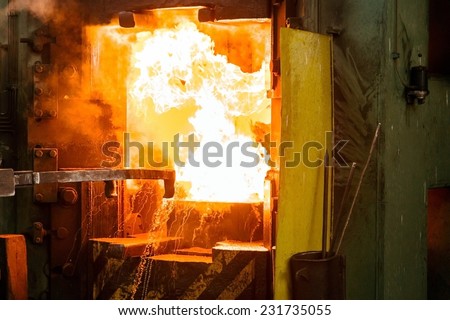 Hot iron in smeltery held by a worker