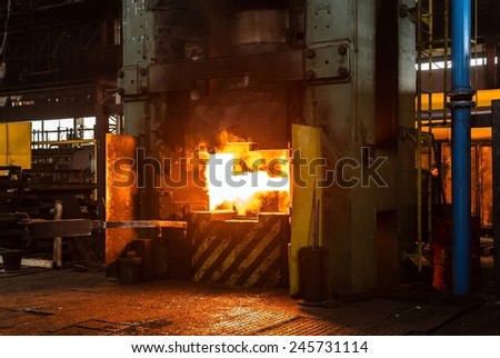 Hot iron in smelter held by a worker