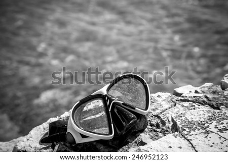 diving goggles on the beach with sea